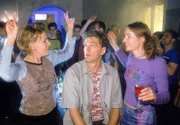 Nikola (Mariele Millowitsch, l.) und Schmidt (Walter Sittler) versuchen auf der Rave-Party einander an Dynamik zu überbieten. Christine (Karo Guthke) beobachtet das Tanzduell amüsiert...