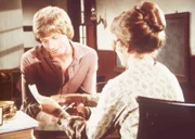 Laura (Melissa Gilbert, r.) zeigt ihrem Mann Almanzo (Dean Butler, l.) einen Brief ihrer Schwägerin Eliza Jane.