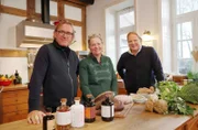 Iris Haver Rassfeld (M) übergibt ihre Küche an Frank Buchholz (l) und Björn Freitag, damit diese dort das Weihnachtsmenü kochen können.
