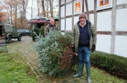 Björn Freitag (r) und Thedel Haver Rassfeld, Sohn des Hofes in Gütersloh, bringen den selbst geschlagenen Tannenbaum ins Haus.