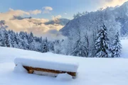 Beautiful morning sunrise view of a bench with fresh powder snow in the mountains of the Brandnertal in the Alps in Vorarlberg, Austria, in winter