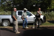 Game Warden Oscar Henson and other law enforcement searching for shotgun shells.