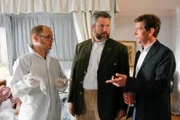 Im Hotelzimmer unterhalten sich die Kommissare Anton Stadler (Dieter Fischer, M.) und Christian Lind (Tom Mikulla, r.) mit einem Spurensicherer (Rudi Schön, l.), der einen Hinweis im aktuellen Fall liefern kann.