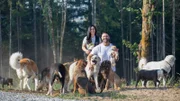 L-R: Sonia Gomez und Lee Asher posieren für ein Familienfoto mit dem Hunderudel.