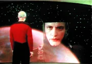 Q (John DeLancie, r.), der über unbegrenzte übersinnliche Kräfte verfügt, erscheint auf dem Bildschirm der Enterprise und warnt Captain Picard (Patrick Stewart, l.).