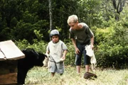 Ole (Harald Lönnbro, r.) und seine kleine Schwester Kerstin (Tove Edfeldt, l.) versuchen, sich mit dem wilden Hund des Schuhmachers Nett anzufreunden.