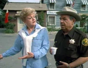 Jessica Fletcher (Angela Lansbury) und Sheriff Amos Tupper (Tom Bosley) diskutieren über einen mysteriösen Mordfall in Cabot Cove. Wer hat den Geschäftsfreund von Charles Woodley umgebracht?