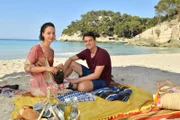Das frisch vermählte Paar Catalina (Amelie Plaas-Link) und Mark (Gerrit Klein) genießen ihre Hochzeitsreise nach Menorca, obwohl Catalina befürchtet, dass die Scharade ihrer Eltern hier auffliegt.