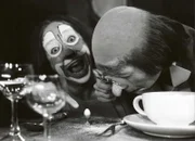 Kellner-Clown Umberto Troni freut sich, dass der Gast Stefano Manca sich über die Größe des Eies wundert.