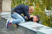 Paul (Daniel Roesner, l.) kommt Semir (Erdogan Atalay) zur Hilfe, der bei dem Sprung von Dach zu Dach abgeruscht ist und nun in die Tiefe zu fallen droht...