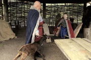 König Sigurd (Johnny McGuinness) bringt Gudrun (Sophie Ryder) eine kleine Ziege, um ihre Knotentechnik zu prüfen.