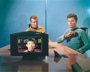 Die Enterprise reagiert auf einen Notruf und stößt auf ein beschädigtes Klingonenschiff. Die Klingonen beschuldigen Kirk (William Shatner, sitzen, links), für den Schaden verantwortlich zu sein. Bald stellt sich heraus, dass beide Schiffe einen gefälschten Notruf empfangen haben. Ein bösartiges Wesen, das sich von Hass ernährt, steckt dahinter. Es lässt die Enterprise-Crew und die Klingonen immer aggressiver werden. Schließlich kommt es zum Kampf.