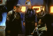 Dr. Franklin (Richard Biggs, li.), Michael Garibaldi (Jerry Doyle), Nummer 1 (Marjorie Monaghan, hinten) und eine Offizierin befinden sich auf einem der Stützpunkte der Erdstreitkräfte auf dem Mars, den sie eingenommen haben.