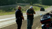 Der Polizist hielt den Motorradfahrer an.