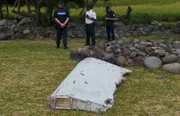French gendarmes and police stand near a large piece of plane debris which was found on the beach in Saint-Andre, on the French Indian Ocean island of La Reunion, July 29, 2015. France's BEA air crash investigation agency said it was examining the debris,  in coordination with Malaysian and Australian authorities, to determine whether it came from Malaysia Airlines Flight MH370, which vanished last year in one of the biggest mysteries in aviation history. Picture taken July 29, 2015.     REUTERS/Zinfos974/Prisca Bigot