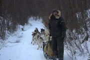 Brent Sass geht mit seinem Schlittenhundegespann in der Nähe seiner Hütte einen Weg entlang (National Geographic/Aaron Blaine).