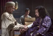 Rob (Tom Payne, Mitte) schaut andächtig zu, während sein Meister Ibn Sina (Ben Kingsley, li.) den verletzten Schah (Oliver Martinez) verarztet.