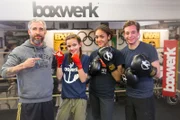 Checker Tobi (rechts) mit Boxtrainer Nick Trachte (links) und Boxschülerinnen.