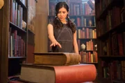 Kyra (Kimie Tsukakoshi) hat in der Bibliothek der Magie einen Stapel alter Bücher entdeckt. Vom obersten Buch wird sie magisch angezogen.