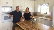 Beth and Jason pose in a kitchen