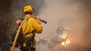 Feuerwehrmann bei der Verlegung von Schläuchen an der Front des Glass Fire außerhalb von Angwin in Napa County, Kalifornien.