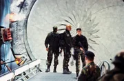 Sam (Amanda Tapping, r.), Daniel (Michael Shanks, l.) und Teal'c (Christopher Judge, M.) können sich nach einem Jaffa-Angriff auf die Erde retten und erstatten Bericht. O'Neill bleibt auf dem Planeten mit einem Leutnant zurück, an den sich in der Stargate Zentrale keiner erinnert ...