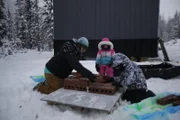 Brittany Rowland und ihre Kinder Elovie und Gilbert helfen ihr beim Bau eines gemauerten Außenofens. (National Geographic/David Wade)