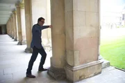 David Tong, theoretischer Physiker an der University of Cambridge, zeigt, dass die Säule, gegen die er schlägt, echt ist.