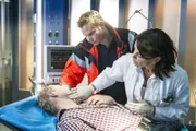 Dr. Jonas (Gerit Kling, r.) und Dr. Haase (Fabian Harloff, M.) entdecken bei ihrem Patienten Stef Lautner (Bernhard Conrad, l.) eine Bissstelle.