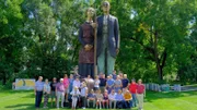 Die Reisegruppe in Anamosa Iowa vor einer Skulptur zur Erinnerung an den Künstler Grant Wood.