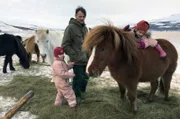 Vater Denni mit den Mädchen beim Füttern der Pferde