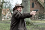 Wilhelm Grebe (Armin Rhode) zielt mit seiner Waffe auf den flüchtenden Anton Mehringer.