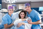 Leyla Sherbaz (Sanam Afrashteh, l.) und Ben Ahlbeck (Philipp Danne, r.) freuen sich über die glückliche Geburt von Zoes (Melina Fabian, M.) Baby.