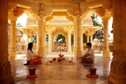 Karan (Faraz Khan) bringt Annie (Stephanie Stumph) an einem heiligen Ort bei, wie man meditiert.