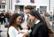 Ordensschwester Lotte (Jutta Speidel, r.) beglückwünscht Sandra (Laura Schneider, l.) und Wolfgang Wöller jr. (Patrick Wolff, 2.v.r.) zu ihrem Baby (Komparse).