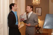 Richard (Karim Köster, r.) konfrontiert David (Mathis Künzler, l.) mit einem Zeitungsartikel, in der ein Verriss der Kollektion von "Kerima-Moda" steht. David aber bleibt gelassen...