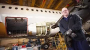 contributor in Hangar with plane in background