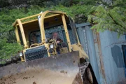 Billy Brown uses the dozer to pull Bear‚Äôs second conex container up the mountain.