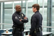 John Nolan (Nathan Fillion, r.) wird von seinem Chef Sergeant Wade Grey (Richard T. Jones, l.) begrüßt.