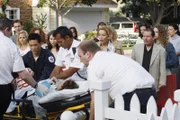 Während der lautstarken Protestaktion gegen Art, erleidet Rebecca (Jennifer Dundas, liegend) einen Herzinfarkt und wird ins Krankenhaus gebracht. Lynette (Felicity Huffman, 4.v.r.) ist außer sich und versucht die Demonstranten zu beruhigen ...