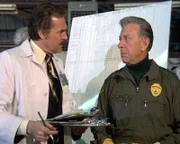 Quincy (Jack Klugman, re.) und  Dr. Astin (John S. Ragin) haben die undankbare Aufgabe die Opfer eines Flugzeugabsturzes zu identifizieren.