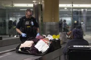 Officer Tighe McIntrye searches through incoming passengers' luggage. (National Geographic/Lucky 8 TV)