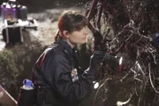 Brennan (Emily Deschanel) untersucht den Fundort einer Leiche, die bereits seit längerer Zeit unter den Wurzeln eines umgefallenen Baumstammes gelegen haben muss.
