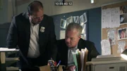 Zwei Detektive untersuchen den Fall im Büro