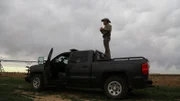 Shot of open field and Texas Game Warden and his vehicle.