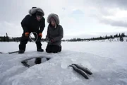 Chris und Jessi Morse beim Eisfischen durch ein Loch im Eis. (National Geographic/Jensen Walker)