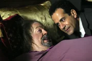 Der Hauptverdächtige in dem Mordfall, Dale the Whale Biederbeck (Tim Curry, li.), bittet Monk (Tony Shalhoub) um Hilfe und verspricht ihm im Gegenzug Informationen zum Tod von Monks Frau Trudy.
