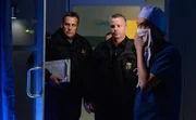 Mit einem Haftbefehl in der Hand suchen Sergeant Cole (Billy Lockwood, M.) und sein Kollege (l.) einen Arzt des Teams. Dr. Topher Zia (Ken Leung) erklärt, dass der besagte Arzt gerade im OP steht.
+++