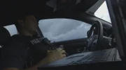 Polizist sitzt in einem Auto