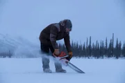 Johnny Rolfe sägt mit der Kettensäge Löcher ins Eis, um ein Fischernetz unter dem zugefrorenen See auszulegen (National Geographic/Mike Fennell).
